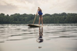 a young girl learning to paddle board